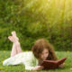 girl on grass with book